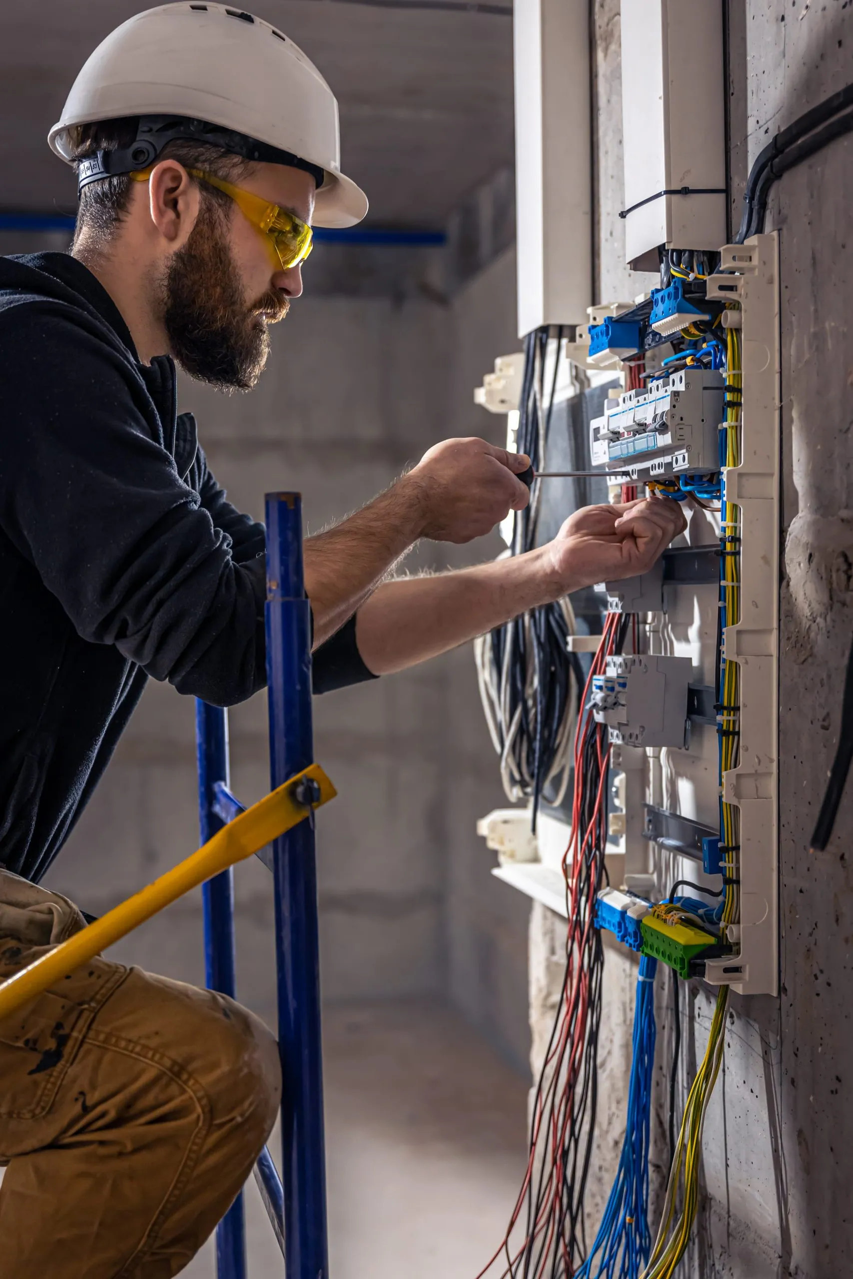 Male electrician working on a switchboard with an electrical connection cable 2